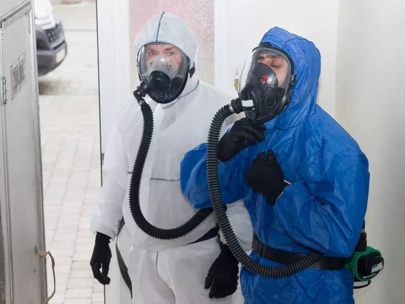 EUROSAN team in volledige beschermingspakken klaar voor asbestverwijdering in hermetische zone